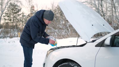 Mann, Der Im Winter Waschflüssigkeit in Tank Des Autos Strömt