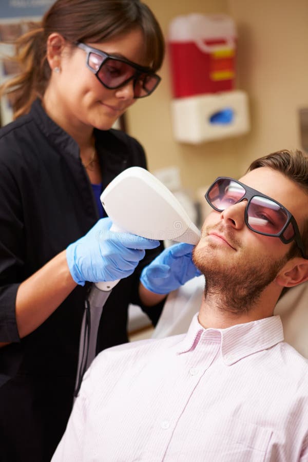 Mann, der Laser-Behandlung an der Schönheits-Klinik hat lizenzfreie stockbilder Mann, der Laser-Behandlung an der Schönheits-Klinik hat lizenzfreie stockbilder