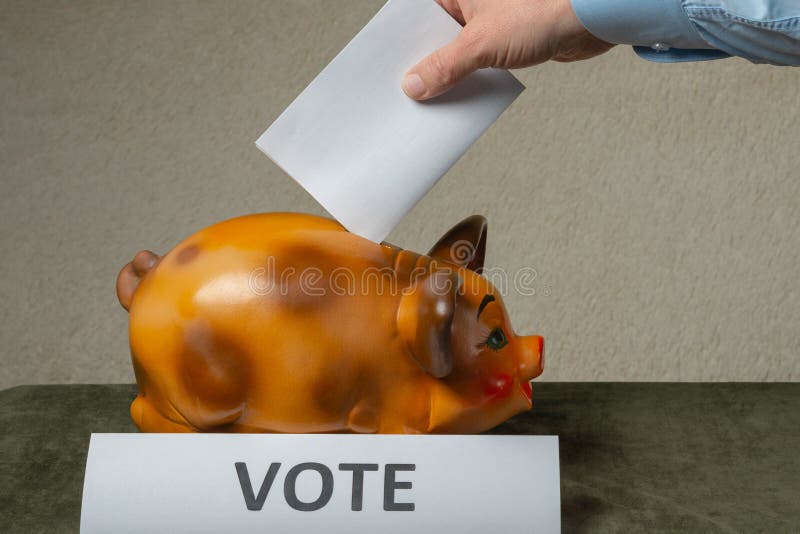 Mann, der seine Abstimmung in Piggibank auf Tabelle setzt lizenzfreies stockfoto Mann, der seine Abstimmung in Piggibank auf Tabelle setzt lizenzfreies stockfoto