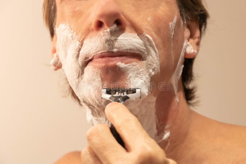 Mann, der seinen Bart mit einem manuellen Rasiermesser rasiert und Schaum rasiert lizenzfreies stockfoto Mann, der seinen Bart mit einem manuellen Rasiermesser rasiert und Schaum rasiert lizenzfreies stockfoto