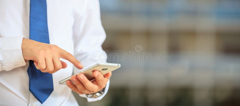 Mann, der Telefon hält Junger Geschäftsmann in der Geschäftsabnutzung unter Verwendung eines beweglichen, Nahaufnahmeansicht über lizenzfreie stockbilder Mann, der Telefon hält Junger Geschäftsmann in der Geschäftsabnutzung unter Verwendung eines beweglichen, Nahaufnahmeansicht über lizenzfreie stockbilder
