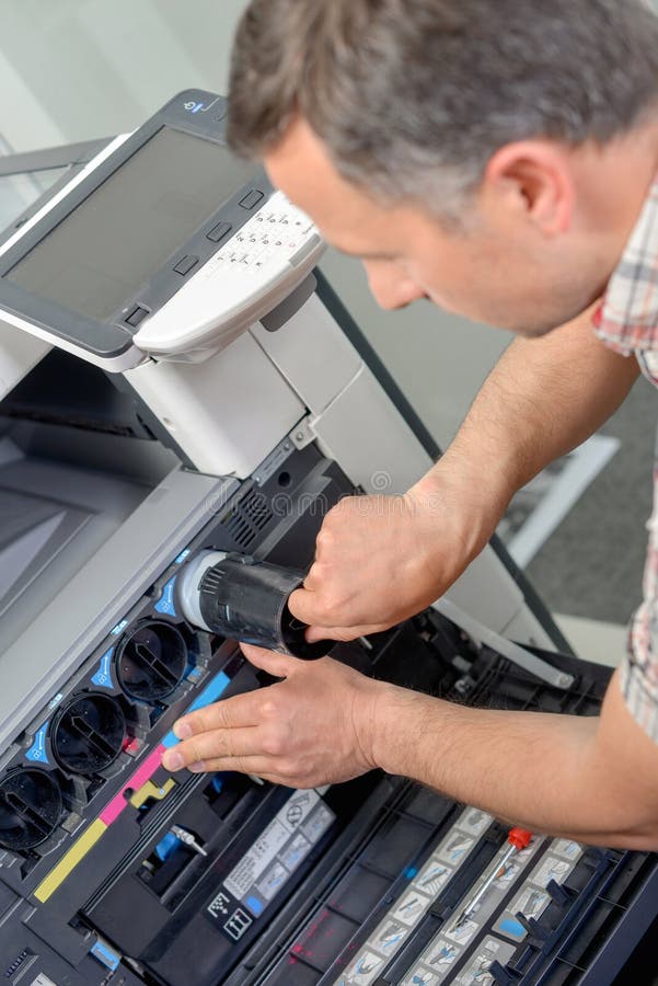 Mann, der Tinte im Drucker ersetzt lizenzfreie stockfotos Mann, der Tinte im Drucker ersetzt lizenzfreie stockfotos