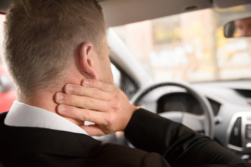 Rear View Of A Man Having Neck Pain While Driving A Car. Rear View Of A Man Having Neck Pain While Driving A Car