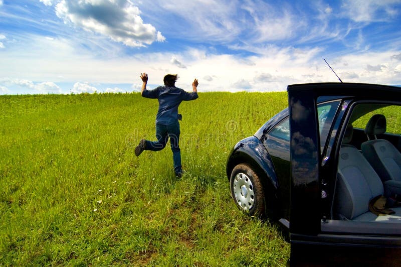 Mann, der vom Auto auf dem geöffneten Gebiet läuft stockfoto Mann, der vom Auto auf dem geöffneten Gebiet läuft stockfoto