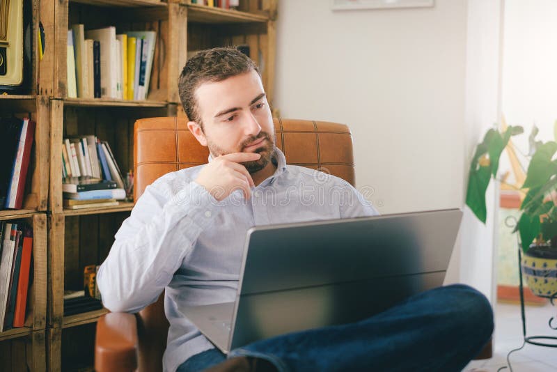 Mann, der zu Hause unter Verwendung seines Laptops arbeitet lizenzfreie stockbilder Mann, der zu Hause unter Verwendung seines Laptops arbeitet lizenzfreie stockbilder
