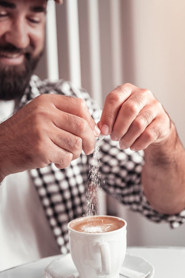 Mann, der Zucker seinem Morgenkaffee hinzufügt stockfoto Mann, der Zucker seinem Morgenkaffee hinzufügt stockfoto