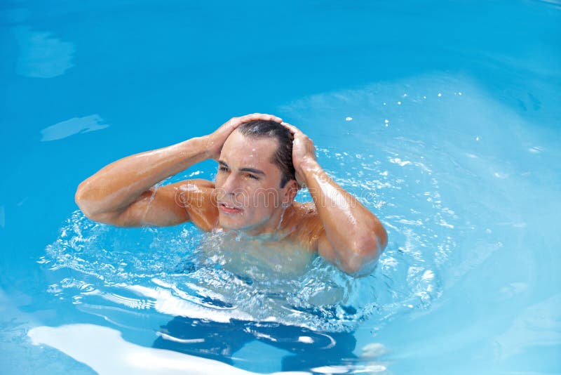 Mann im Pool, das sein Haar naßmacht stockfoto Mann im Pool, das sein Haar naßmacht stockfoto