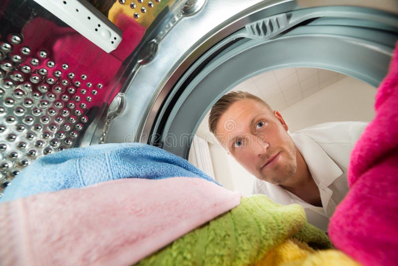 Mann-Innenansicht die Waschmaschine stockfotografie Mann-Innenansicht die Waschmaschine stockfotografie