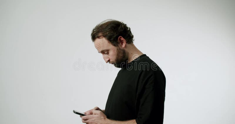 Mann läuft und sieht sein Smartphone im weißen Hintergrund an stock video footage