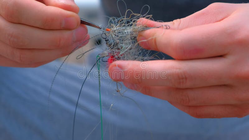 Mann löst eine Angelschnur und Lasthaken, die für die Fischerei der Handnahaufnahme vorbereiten.