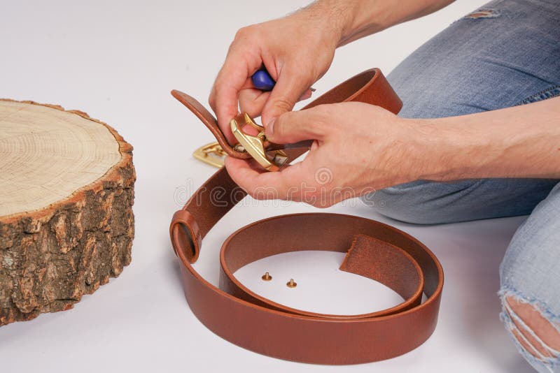 Mann macht durch Handledergürtel mit Schnalle Handgemachtes Hobby junger Mann, der durch Fertigung seine Designergurte stillsteht stockfotos Mann macht durch Handledergürtel mit Schnalle Handgemachtes Hobby junger Mann, der durch Fertigung seine Designergurte stillsteht stockfotos