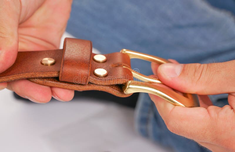 Mann macht durch Handledergürtel mit Schnalle Handgemachtes Hobby junger Mann, der durch Fertigung seine Designergurte stillsteht stockfoto Mann macht durch Handledergürtel mit Schnalle Handgemachtes Hobby junger Mann, der durch Fertigung seine Designergurte stillsteht stockfoto