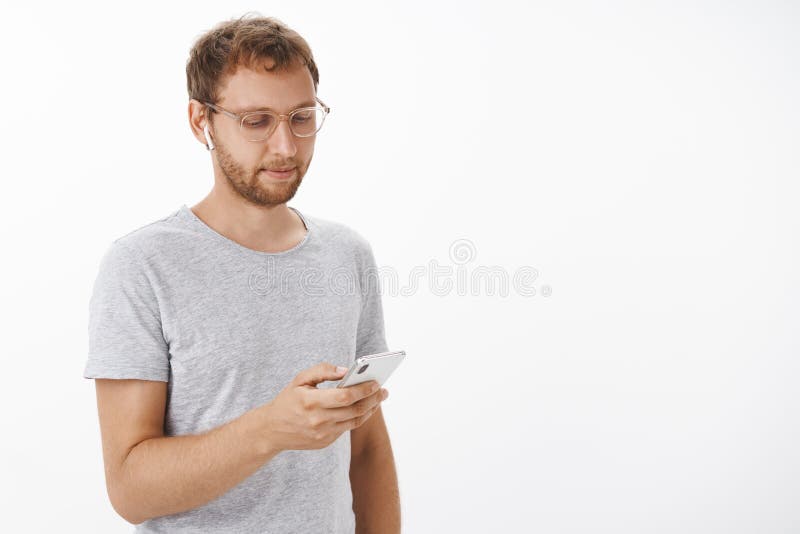 Mann mag Arbeit mit Musik in den Ohren Porträt des entspannten sorglosen gewöhnlichen Mannes mit Borste in den Gläsern herein gra stockfotografie Mann mag Arbeit mit Musik in den Ohren Porträt des entspannten sorglosen gewöhnlichen Mannes mit Borste in den Gläsern herein gra stockfotografie