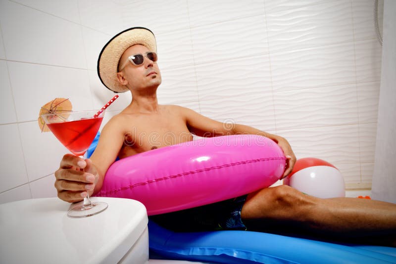 Mann mit einem Schwimmenring, der im Badezimmer sich entspannt stockfoto Mann mit einem Schwimmenring, der im Badezimmer sich entspannt stockfoto