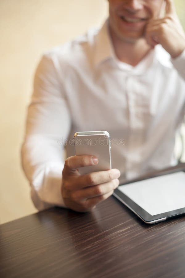 Mann mit smartphone im Büro lizenzfreie stockfotografie Mann mit smartphone im Büro lizenzfreie stockfotografie