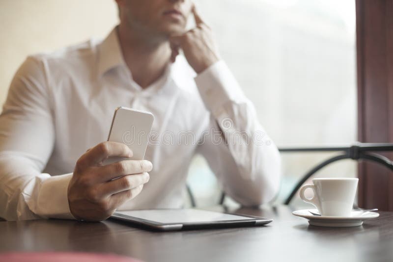Geschäftsmann mit smartphone im Café stockfotografie Geschäftsmann mit smartphone im Café stockfotografie