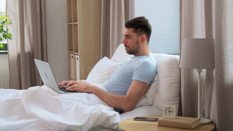 Mann mit Laptop im Bett zu Hause Schlafzimmer