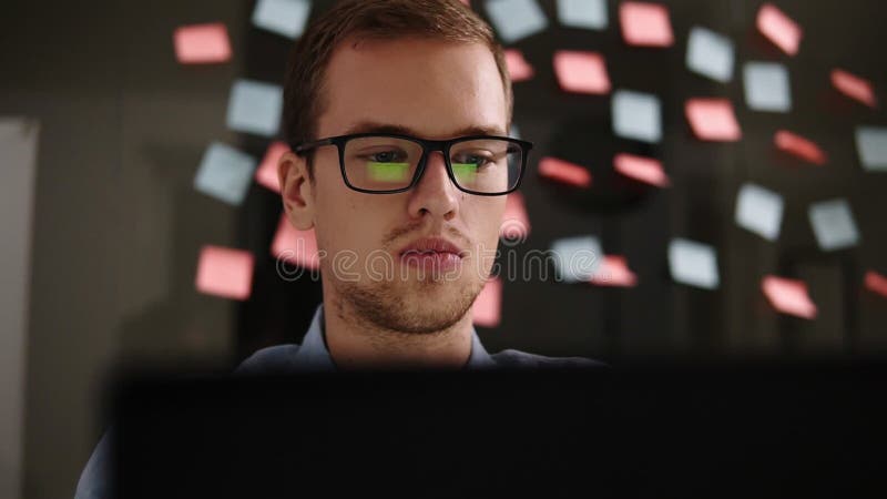 Mann mit Laptop Junger Mann in der Glasfunktion an einem Laptop im Büro Geschäftsmann - Büroangestellter Arbeit des männlichen St