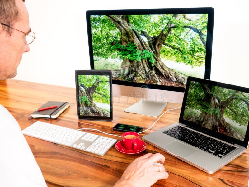 Mann mit vernetzten Computern und tragbaren Geräten stockbilder Mann mit vernetzten Computern und tragbaren Geräten stockbilder