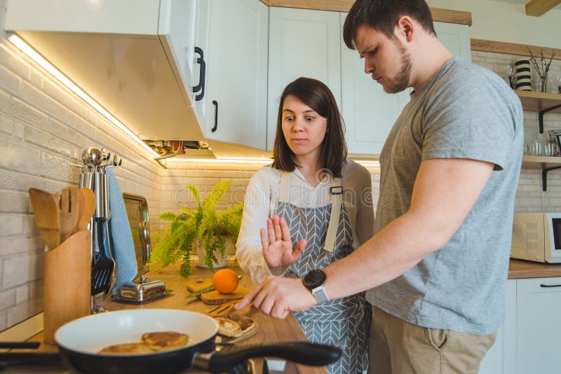 Mann stiehlt Nahrung während die Frau, die Frühstück macht stockfoto Mann stiehlt Nahrung während die Frau, die Frühstück macht stockfoto