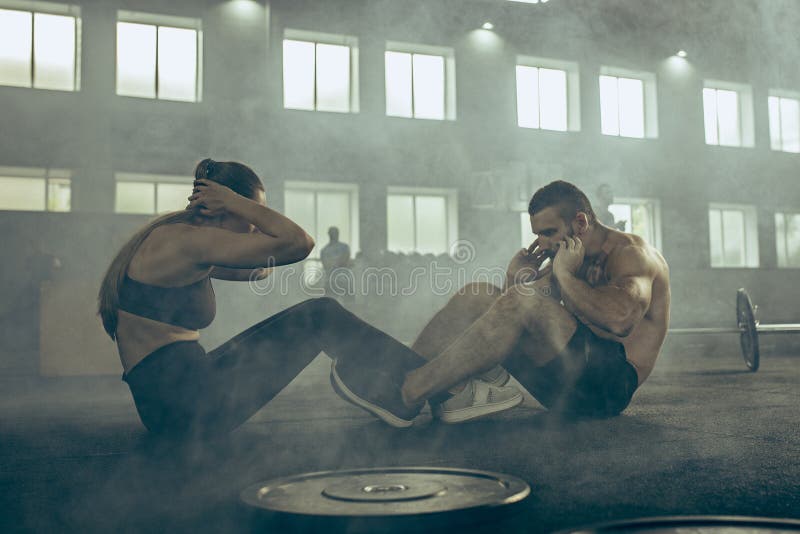 Mann und Frau während der Übungen in der Eignungsturnhalle Crossfit stockbilder Mann und Frau während der Übungen in der Eignungsturnhalle Crossfit stockbilder
