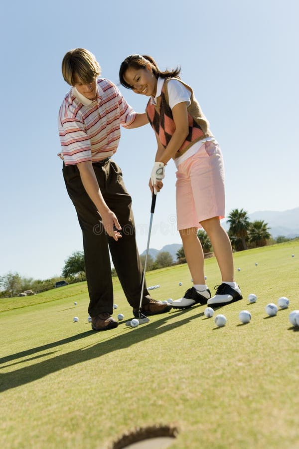 Mann-unterrichtende Frau, zum des Golfs zu spielen stockfotos Mann-unterrichtende Frau, zum des Golfs zu spielen stockfotos
