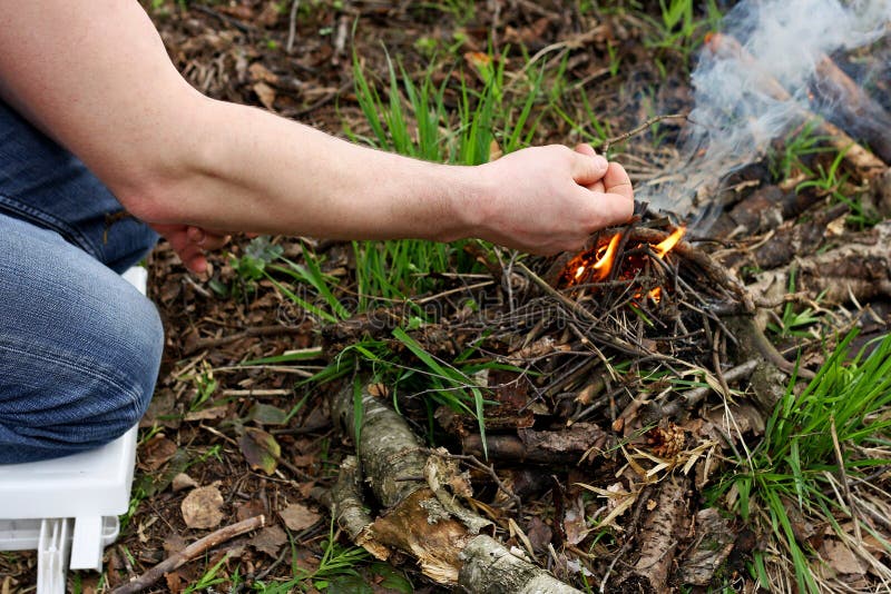 Mann zünden ein Feuer im Wald an stockfoto Mann zünden ein Feuer im Wald an stockfoto