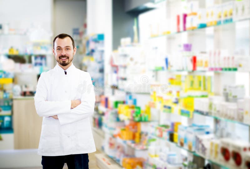 Mannelijke apotheker die assortiment van drugs tonen royalty-vrije stock afbeeldingen Mannelijke apotheker die assortiment van drugs tonen royalty-vrije stock afbeeldingen