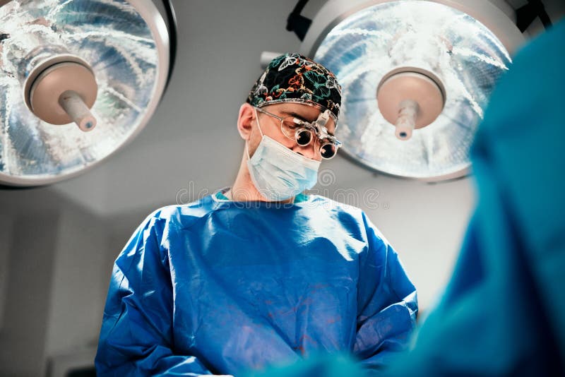 Mannelijke Chirurg die chirurgie in het ziekenhuis werkend theater uitvoeren stock fotografie Mannelijke Chirurg die chirurgie in het ziekenhuis werkend theater uitvoeren stock fotografie