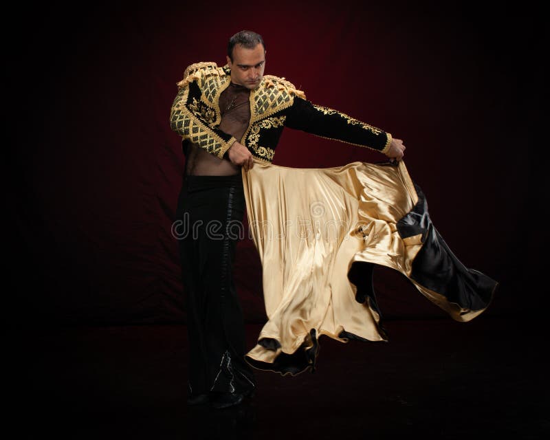 Male dancer dressed as a matador on a dark background. Male dancer dressed as a matador on a dark background.