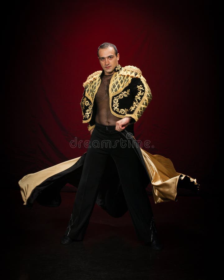 Male dancer dressed as a matador on a dark background. Male dancer dressed as a matador on a dark background.