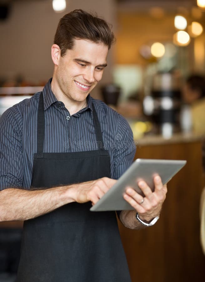 Mannelijke Eigenaar die Digitale Tablet in Cafetaria gebruiken royalty-vrije stock afbeelding Mannelijke Eigenaar die Digitale Tablet in Cafetaria gebruiken royalty-vrije stock afbeelding