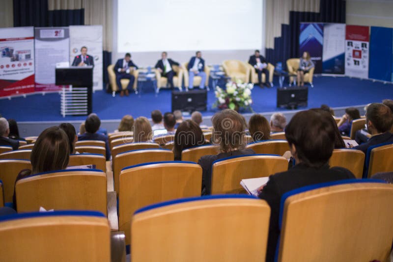 Mannelijke Gastheer die op Stadium tijdens Handelsconferentie in Grote Congreszaal spreken stock afbeelding Mannelijke Gastheer die op Stadium tijdens Handelsconferentie in Grote Congreszaal spreken stock afbeelding