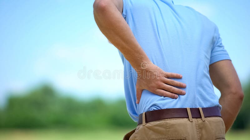 Mannelijke gevoel van een scherpe lagere rugpijn in de buitenlucht, gezondheid en problemen, geneesmiddel