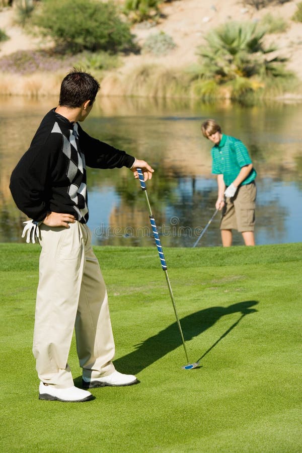Mannelijke Golfspeler die Zijn Concurrent bekijken royalty-vrije stock afbeeldingen Mannelijke Golfspeler die Zijn Concurrent bekijken royalty-vrije stock afbeeldingen