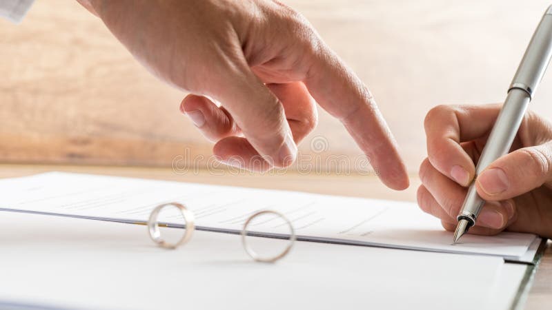 Mannelijke hand die aan een scheidingsdocument richten stock afbeeldingen Mannelijke hand die aan een scheidingsdocument richten stock afbeeldingen