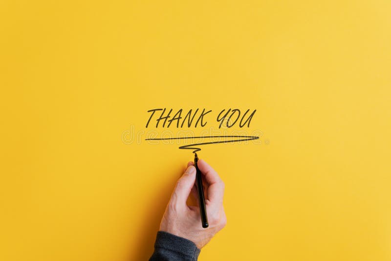 Male hand writing a Thank you sign with black marker on a yellow background. With copy space ready for your text. Male hand writing a Thank you sign with black marker on a yellow background. With copy space ready for your text