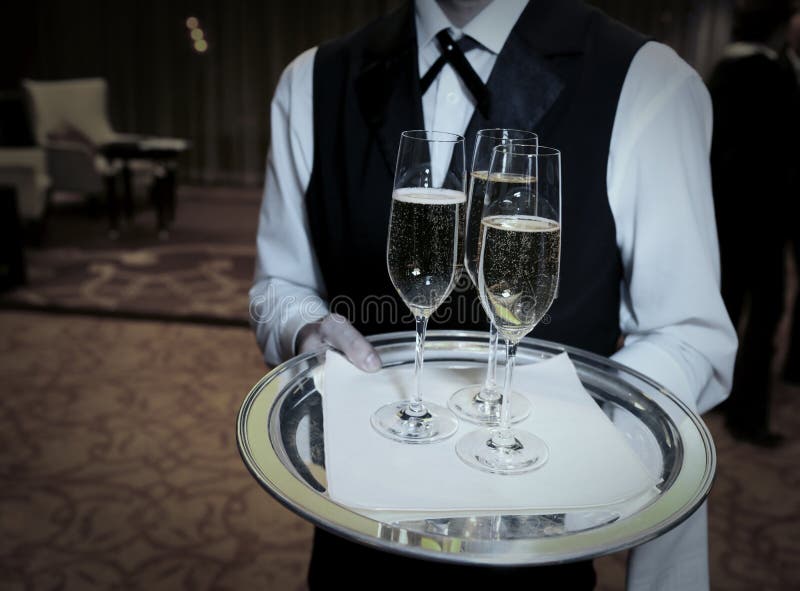 Waiter welcomes guests with champagne. Waiter welcomes guests with champagne