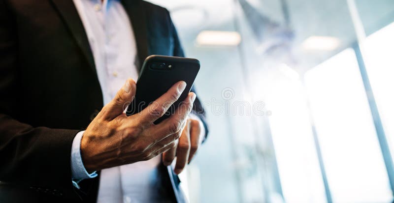Mannelijke ondernemer met mobiele telefoon in bureau