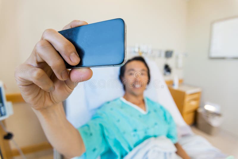 Mannelijke Patiënt die Zelfportret nemen door Mobiel royalty-vrije stock afbeelding Mannelijke Patiënt die Zelfportret nemen door Mobiel royalty-vrije stock afbeelding