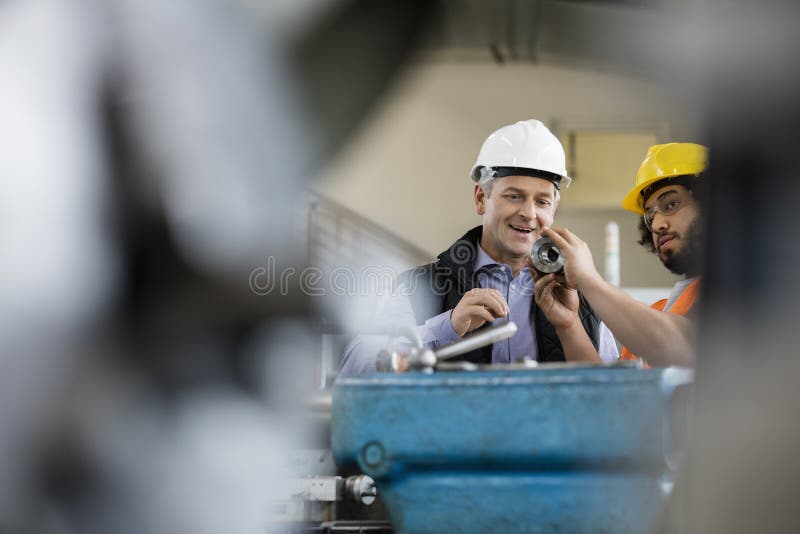 Mannelijke supervisor met arbeider die metaal in de industrie onderzoeken royalty-vrije stock afbeeldingen Mannelijke supervisor met arbeider die metaal in de industrie onderzoeken royalty-vrije stock afbeeldingen