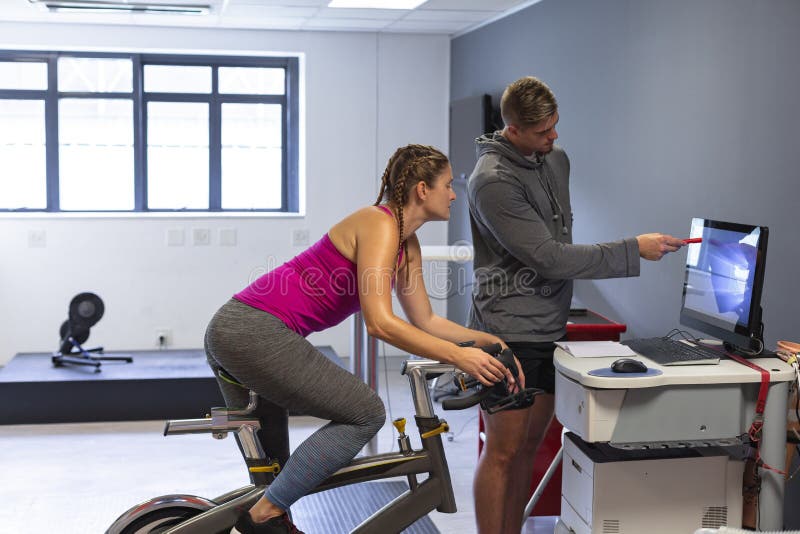 Mannelijke trainer en het vrouwelijke atletische bespreken over computer in geschiktheidscentrum royalty-vrije stock foto's Mannelijke trainer en het vrouwelijke atletische bespreken over computer in geschiktheidscentrum royalty-vrije stock foto's