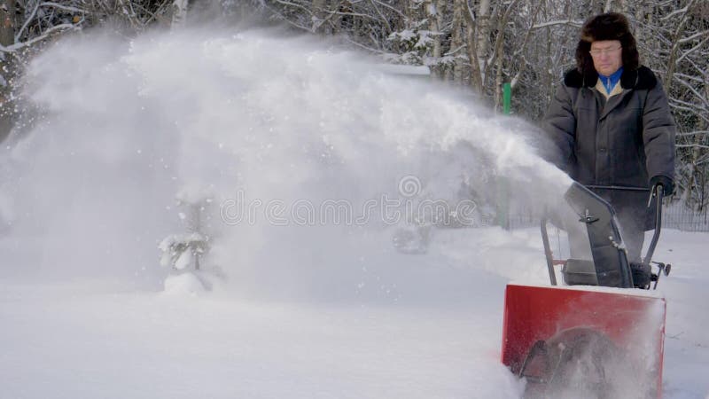 Mannen gör ren snö med bakgrund för maskinen för snöborttagning Forest In Winter