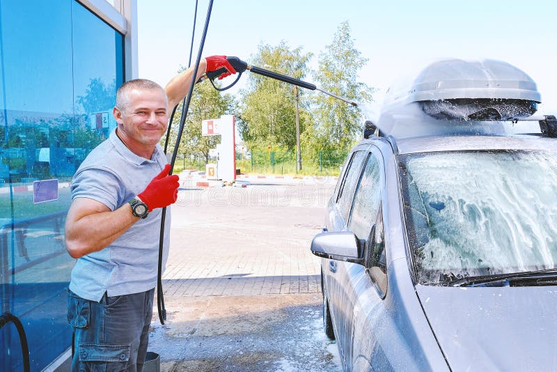 Mannen häller den aktiva skumbilkroppen f?r slangmaskin f?r bil clean wash f?r svamp E r royaltyfria bilder Mannen häller den aktiva skumbilkroppen f?r slangmaskin f?r bil clean wash f?r svamp E r royaltyfria bilder