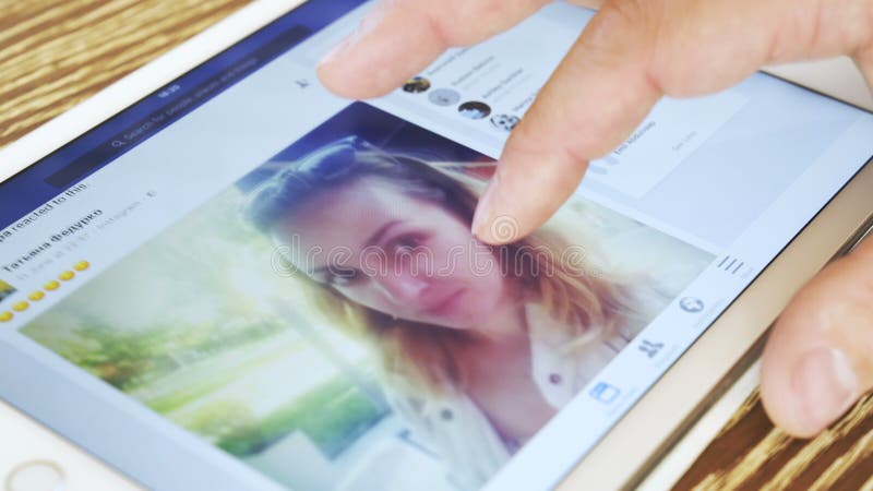 Mannen håller ögonen på den Facebook applikationen på vit iPad
