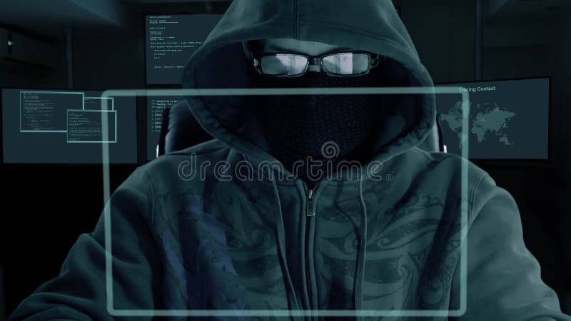Mannen i huvexponeringsglas och maskering av balaclavaen sitter på datorbärbara datorn och nedladdar hemliga data En en hacker på