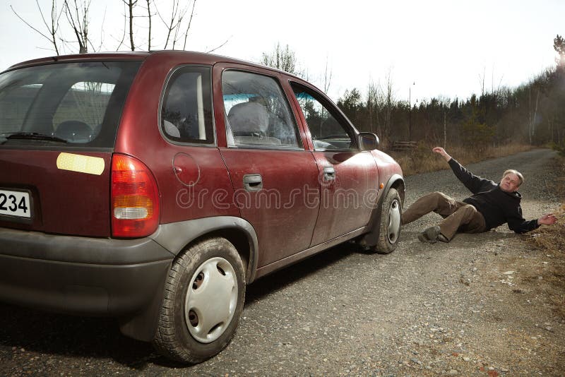 Mannen i med huva skjorta slogg med bilen på den dammiga vägen och som lämnade på sida arkivfoton Mannen i med huva skjorta slogg med bilen på den dammiga vägen och som lämnade på sida arkivfoton