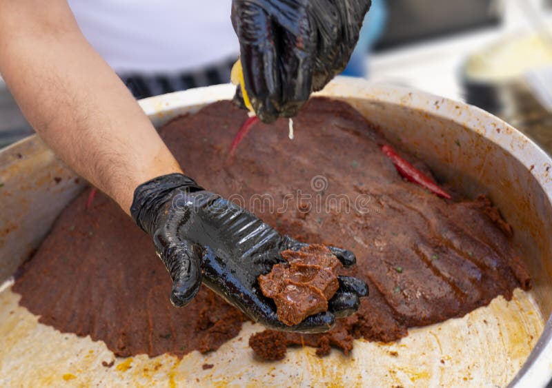 Mannen knådar cigkofte för rått kött med traditionell metod royaltyfria bilder Mannen knådar cigkofte för rått kött med traditionell metod royaltyfria bilder