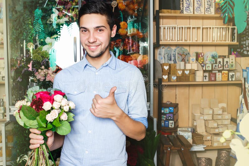 Mannen köper blommor på en blomsterhandel rymma en bukett i hand royaltyfria bilder Mannen köper blommor på en blomsterhandel rymma en bukett i hand royaltyfria bilder