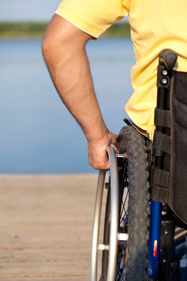 Detail shot of a man operating wheelchair. Detail shot of a man operating wheelchair